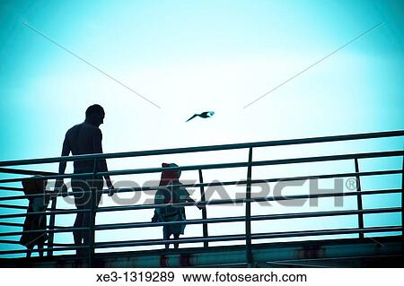 Stock Photo - Father and sons at the sunset, Madalena do Mar, Madeira.. Fotosearch
