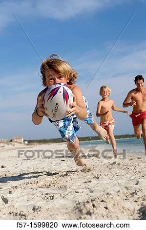 Father and sons playing ball on the beach View Large Photo Image Stock Image - Father and sons playing ball on the beach. Fotosearch