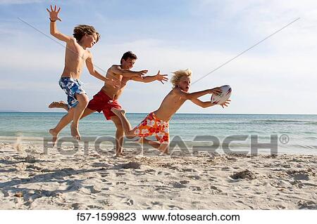 Father and sons playing ball on the beach View Large Photo Image Stock Image - Father and sons playing ball on the beach. Fotosearch