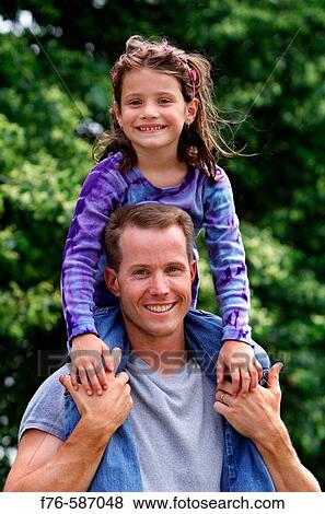 Father carrying his daughter on his shoulders. View Large Photo Image Stock Photo - Father carrying his daughter on his shoulders.. Fotosearch
