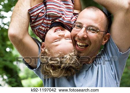 Father holding child upside-down View Large Photo Image Stock Image - Father holding child upside-down. Fotosearch