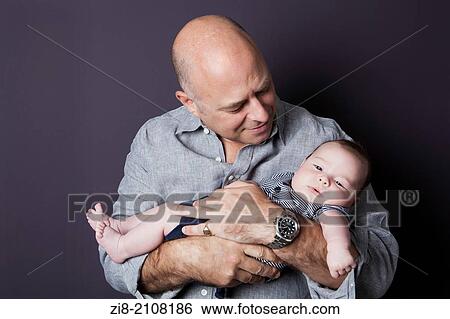 Stock Photograph - Father holding his baby son.. Fotosearch