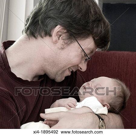 Stock Image - Father holding newborn. Fotosearch