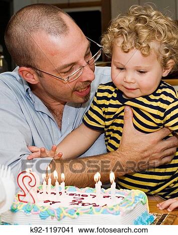 Father holding son at birthday party View Large Photo Image Stock Image - Father holding son at birthday party. Fotosearch