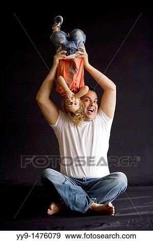 Father holding son upside down - Fort Lauderdale, Florida USA View Large Photo Image Stock Photo - Father holding son upside down - Fort Lauderdale, Florida USA. Fotosearch