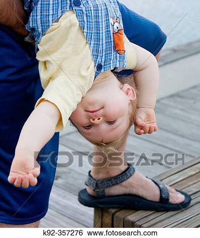 Stock Photograph - Father holds his one year old son upsidedown. Fotosearch