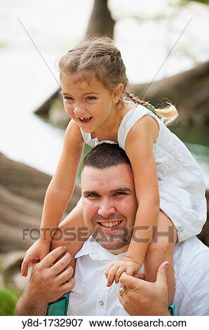 Stock Photo - Father letting his daughter ride on his shoulders. Fotosearch
