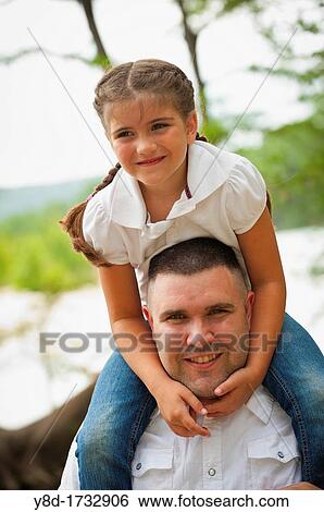 Stock Photograph - Father letting his daughter ride on his shoulders. Fotosearch