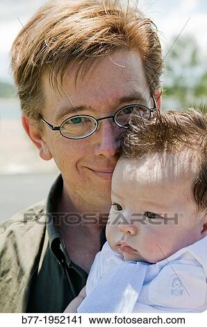 father lovingly holding his firstborn son. View Large Photo Image Stock Image - father lovingly holding his firstborn son.. Fotosearch