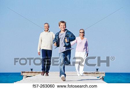 Father, mother and child walking in a wooden footbridge over the sea View Large Photo Image Stock Image - Father, mother and child walking in a wooden footbridge over the sea. Fotosearch