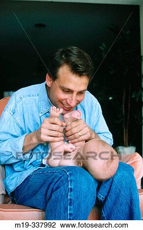 Stock Image - Father playing with baby. Fotosearch