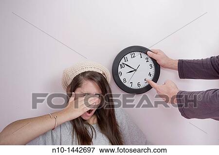 Father pointing to a clock next to his teen daughter View Large Photo Image Stock Photo - Father pointing to a clock next to his teen daughter. Fotosearch