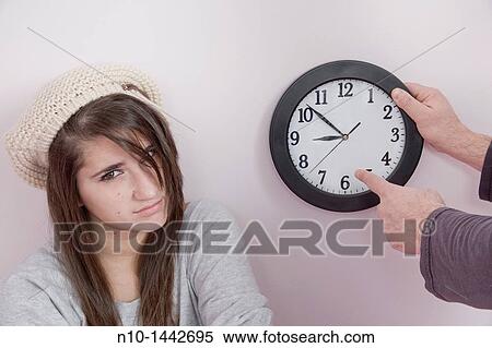 Father pointing to a clock next to his teen daughter View Large Photo Image Stock Photography - Father pointing to a clock next to his teen daughter. Fotosearch