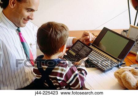 Stock Image - Father showing son an electronic organizer. Fotosearch