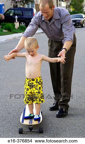 father teaching son balance on skateboard View Large Photo Image Picture - father teaching son balance on skateboard. Fotosearch