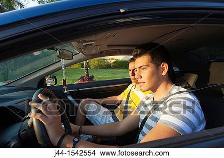 Picture - Father teaching son to drive in the street. Fotosearch