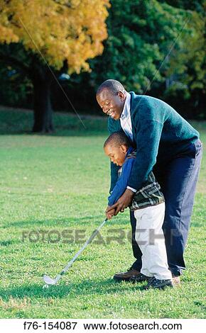 Father teaching son to play golf View Large Photo Image Stock Photo - Father teaching son to play golf. Fotosearch