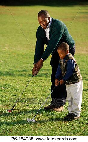 Stock Photo - Father teaching son to play golf. Fotosearch