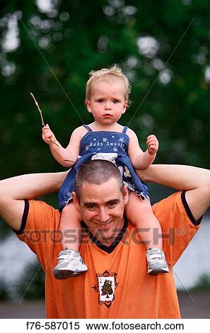 Stock Photography - Father with 1 year old daughter on his shoulder.. Fotosearch