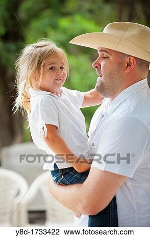 Father with cowboy hat carrying his cute four years old daughter View Large Photo Image Stock Image - Father with cowboy hat carrying his cute four years old daughter. Fotosearch