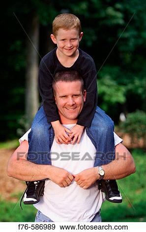 Stock Photo - Father with son sitting on his shoulders.. Fotosearch