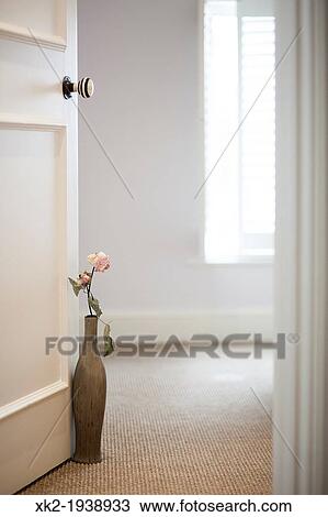 Stock Image - Feeling calm, pink flower and vase keeping the door open. Fotosearch