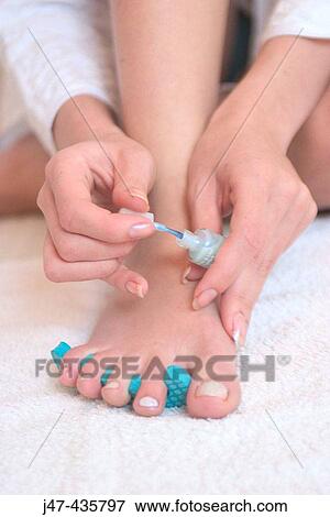 Feet and hands of a girl applying nail varnish View Large Photo Image Stock Photo - Feet and hands of a girl applying nail varnish. Fotosearch