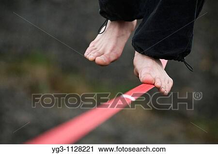 Stock Image - Feet of Person walking highline. Fotosearch