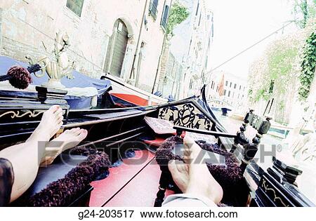 Stock Photo - Feet of tourists in gondola. Venice. Italia. Fotosearch