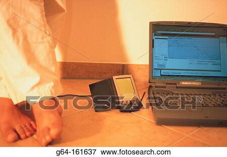 Stock Photo - Feet, palm pilot and laptop computer. Fotosearch
