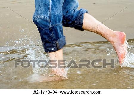 feet wet man walking on the shore of the Sea, Spain, Europe View Large Photo Image Picture - feet wet man walking on the shore of the Sea, Spain, Europe. Fotosearch