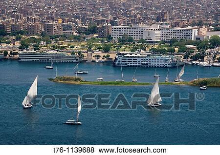 feluccas and cruise ships sailing on the Nile River in Aswan Egypt View Large Photo Image Stock Photo - feluccas and cruise ships sailing on the Nile River in Aswan Egypt. Fotosearch