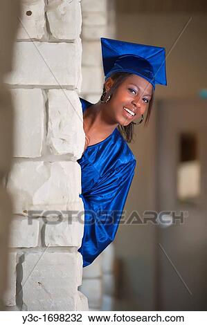 Stock Image - Female African American Student Portrait in Graduation Outfit on highschool campus. Fotosearch