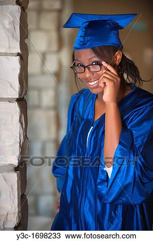 Stock Image - Female African American Student Portrait in Graduation Outfit on College Campus. Fotosearch