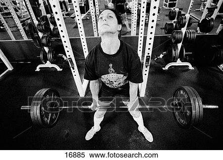 Stock Photography - Female bodybuilder deadlifting 330 lbs barbell in gym. Fotosearch
