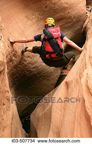 Female canyoneer stemming across a sandstone slot in Pritchett Canyon near Moab, Utah, USA View Large Photo Image Picture - Female canyoneer stemming across a sandstone slot in Pritchett Canyon near Moab, Utah, USA. Fotosearch