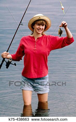 Stock Image - Female catches tiny fish. Fotosearch