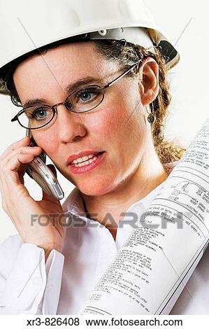 Female caucasian architect with hard hat talking on cell phone and holding drawings View Large Photo Image Stock Photo - Female caucasian architect with hard hat talking on cell phone and holding drawings. Fotosearch