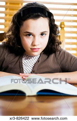 Female caucasian brunette child reading a textbook sitting at a table View Large Photo Image Stock Image - Female caucasian brunette child reading a textbook sitting at a table. Fotosearch
