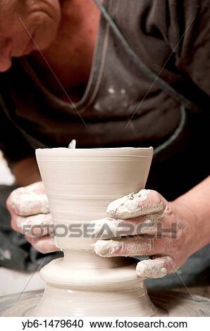 Female ceramicist using a Potter's wheel to work on a ceramic piece in her workshop, Barcelona, SPAIN View Large Photo Image Stock Image - Female ceramicist using a Potter's wheel to work on a ceramic piece in her workshop, Barcelona, SPAIN. Fotosearch