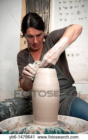 Female ceramicist using a Potter's wheel to work on a ceramic piece in her workshop, Barcelona, SPAIN View Large Photo Image Stock Image - Female ceramicist using a Potter's wheel to work on a ceramic piece in her workshop, Barcelona, SPAIN. Fotosearch