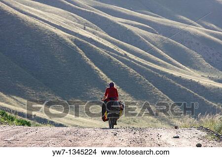 Female cyclist on a mountain road, Kyrgyzstan View Large Photo Image Picture - Female cyclist on a mountain road, Kyrgyzstan. Fotosearch