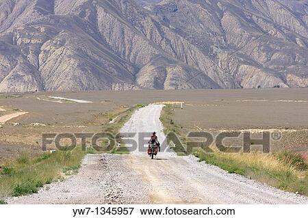 Female cyclist on a mountain road, leading from Kazarman to Naryn, Kyrgyzstan View Large Photo Image Stock Photo - Female cyclist on a mountain road, leading from Kazarman to Naryn, Kyrgyzstan. Fotosearch