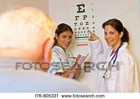 Female doctor, checking a patients, eyesight with eye chart, with female medical assistant, taking notes View Large Photo Image Stock Image - Female doctor, checking a patients, eyesight with eye chart, with female medical assistant, taking notes. Fotosearch