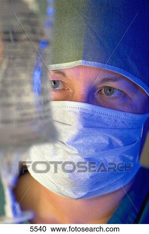 Stock Image - Female doctor checks I. V. bag. Fotosearch