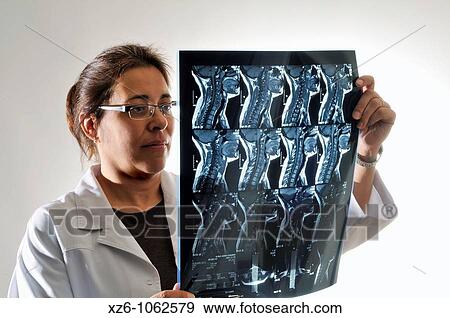 Female doctor examining an x-ray report, Doctora examinando una radiograf? a View Large Photo Image Stock Photo - Female doctor examining an x-ray report, Doctora examinando una radiograf? a. Fotosearch
