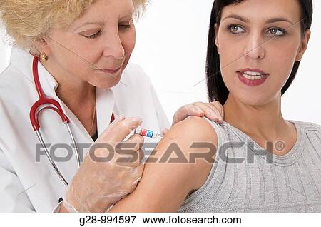 female doctor vaccinating or giving an injection to young woman patient View Large Photo Image Stock Photo - female doctor vaccinating or giving an injection to young woman patient. Fotosearch