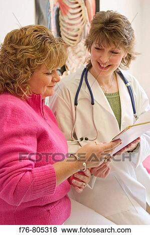 Female doctor with stethoscope reviewing medical history of female patient View Large Photo Image Stock Photo - Female doctor with stethoscope reviewing medical history of female patient. Fotosearch