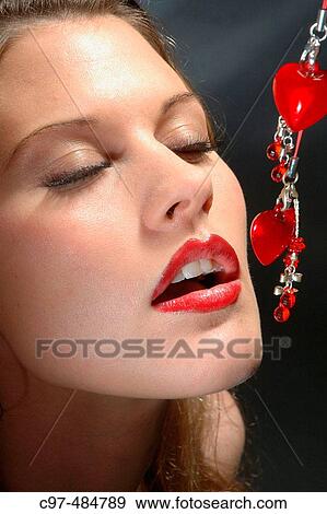 Stock Photo - Female face close, eyes closed, desires red ornament. Fotosearch
