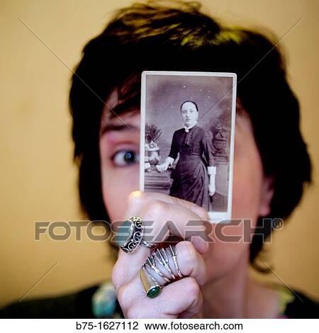 Stock Image - Female half hidden behind old portrait. Fotosearch